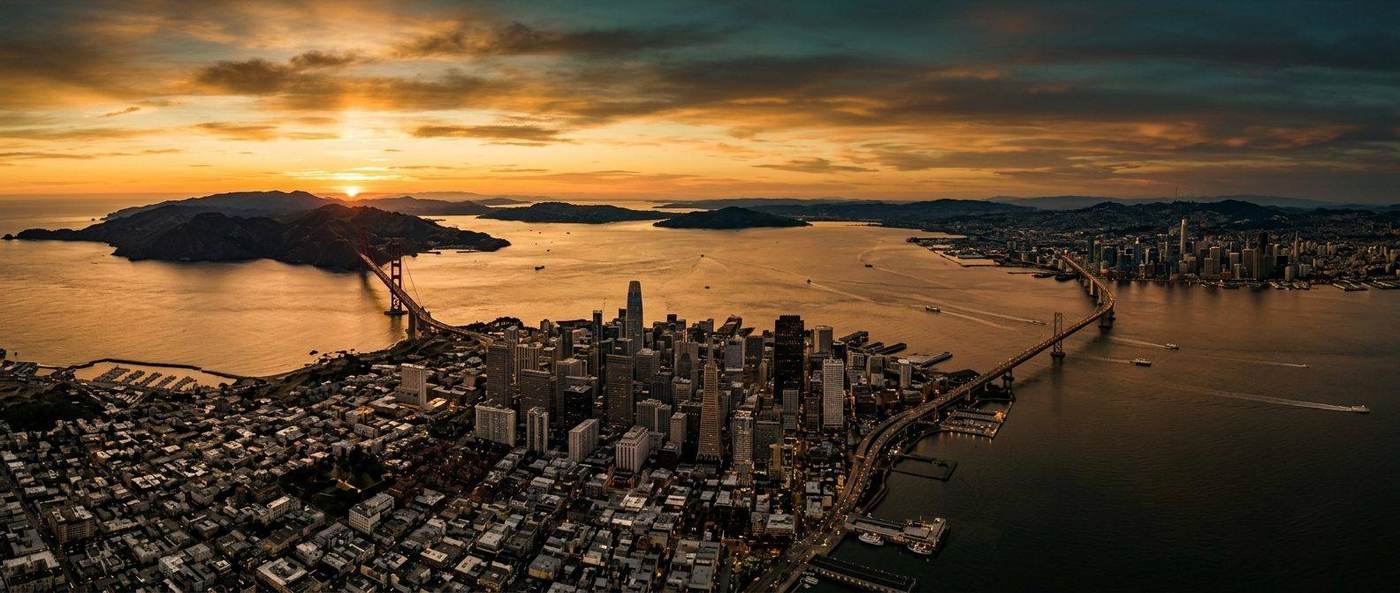 Aerial view of San Francisco Bay Area skyline at golden hour with Golden Gate Bridge